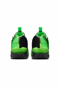Zwarte en groene sportschoenen met een gestructureerd materiaal, opvallende richels aan de zijkanten en een solide zwarte zool voor stabiliteit.