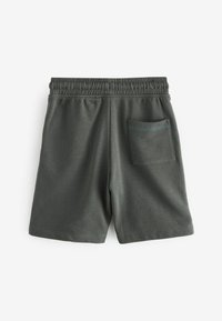 Shorts en coton vert foncé avec une taille élastique, dotés d'une poche arrière avec une couture contrastante. Texture lisse et design simple.