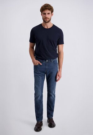 Dunkelblaues T-Shirt und hellblaue Jeans aus Denim. Die Jeans haben eine schmal geschnittene Passform mit einer leichten Ausbleichung und werden mit dunkelbraunen Schuhen kombiniert. Einfaches Design.