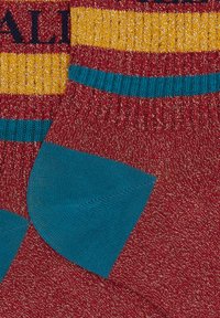 Ein Paar gestrickte Socken mit kastanienbraun, petrol und goldenen Streifen, ausgestattet mit einer petrolfarbenen Ferse und gerippten Bündchen.