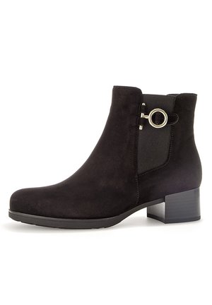 Black suede ankle boot with a round silver hardware accent, elastic side panel, and a low block heel. Smooth texture and minimalist design.