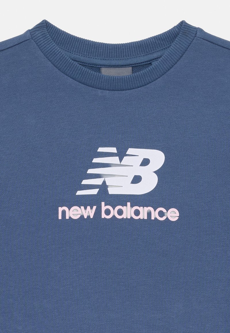 Sweatshirt en coton bleu avec un col côtelé et un grand logo "new balance" blanc et rose centré sur la poitrine. Texture douce.
