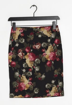 Sort pencilnederdel med rød, pink, beige og grøn blomsterdekoration, hængende på en sort bøjle mod en hvid baggrund.