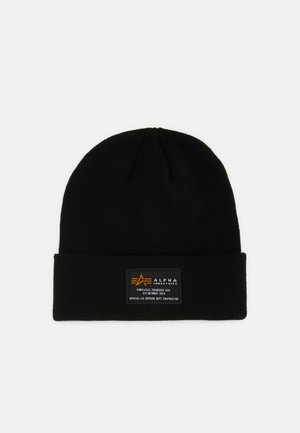 Gorro de malha preto com uma aba dobrada, apresentando uma etiqueta retangular com texto e logótipo em laranja e branco, feito de um tecido flexível e texturizado.