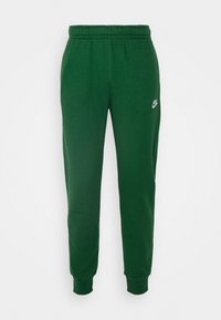 Gröna bomullsbyxor med elastisk midja, smalnande ben och en liten Nike-logga på vänster lår. Slät textur.