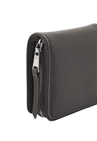 Czarny skórzany portfel o gładkiej fakturze, zamykany na zamek, z srebrnymi akcentami. Charakteryzuje się zaokrąglonymi krawędziami.