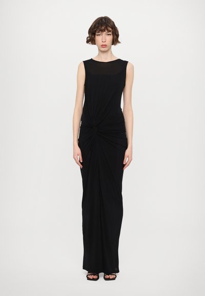 Robe noire sans manches avec un corsage ajusté, détail de nœud torsadé à la taille et une jupe fluide. Tissu lisse et design longueur maxi.
