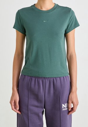 Camiseta de algodón verde con cuello redondo y mangas cortas, que presenta un pequeño logo de Nike en verde a juego en el pecho.
