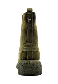 Botín ankle verde de ante con suela de goma texturizada, asa en la parte trasera y parche con la marca que presenta el eslogan "GIOSERPRO" en la parte trasera.