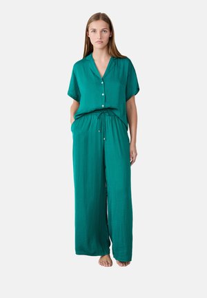 Completo turchese composto da camicia a maniche corte con bottoni e pantaloni larghi con vita elastica e tasche sui lati. Tessuto morbido e leggero.