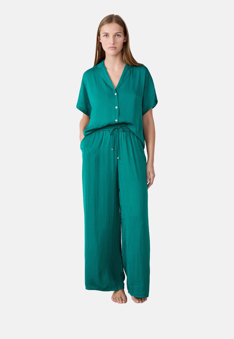 Turquoise tweedelig set bestaande uit een kortogende, knoopsluiting shirt en wijde broek met een elastische taille en zijzakken. Zacht, lichtgewicht stof.