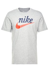 Gray cotton T-shirt featuring a large navy blue "nike" logo and a red Nike swoosh graphic. Short sleeves, crew neck design.