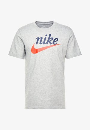 Grå bomullströja med en stor marinblå "nike"-logotyp och en röd Nike-swoosh grafik. Kortärmad, design med rund hals.