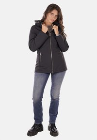 Giacca nera con zip e cappuccio, dotata di due tasche laterali e un design leggermente aderente. Il tessuto è liscio e resistente all'acqua.