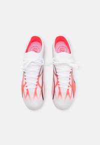 Scarpe sportive bianche con accenti rosa, dotate di una parte superiore in mesh traspirante, lacci piatti e una suola testurizzata.