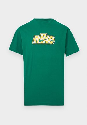Grünes T-Shirt mit kurzen Ärmeln und einem gelb-weiß karierten Nike-Logo, das mittig auf der Brust vor weißem Hintergrund platziert ist.
