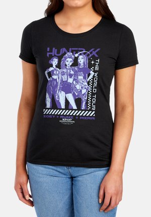 Three animated female characters in purple on a black shirt with "HUNTRXX The World Tour" and names Zoey, Rumi, and Mira.