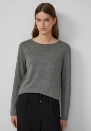 Grauer langärmeliger Pullover mit einem runden Ausschnitt, aus weichem Stoff. Hat eine lockere Passform und leichte Textur, kombiniert mit schwarzen Hosen.