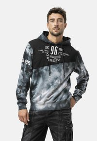 Hoodie met een zwart bovenstuk en een grijze tie-dye onderkant. Voorzien van grafische prints, een trekkoord en geribbelde boorden.