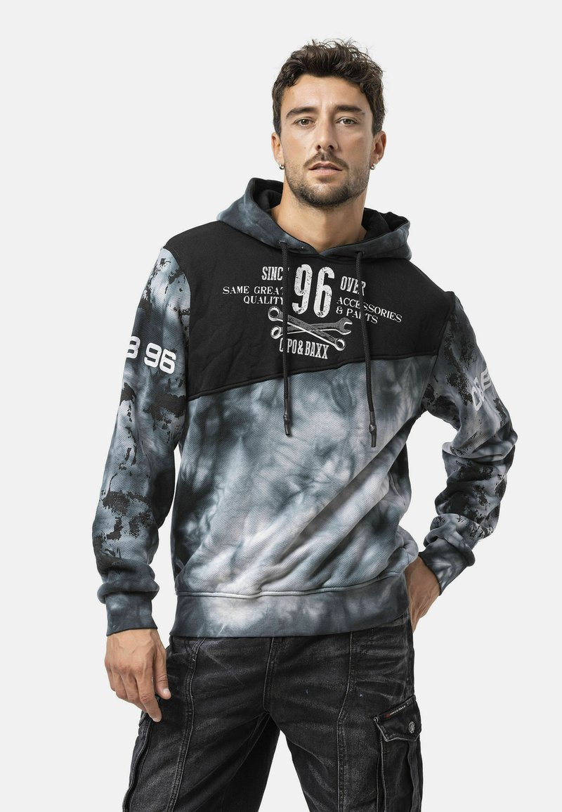 Hoodie met een zwart bovenstuk en een grijze tie-dye onderkant. Voorzien van grafische prints, een trekkoord en geribbelde boorden.