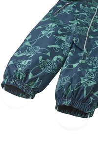 Námornícky nepremokavý zimný overal s zeleným abstraktným vzorom zvierat, elastickými manžetami a slučkami na nohách na zabezpečenie topánok. Zips vpredu.