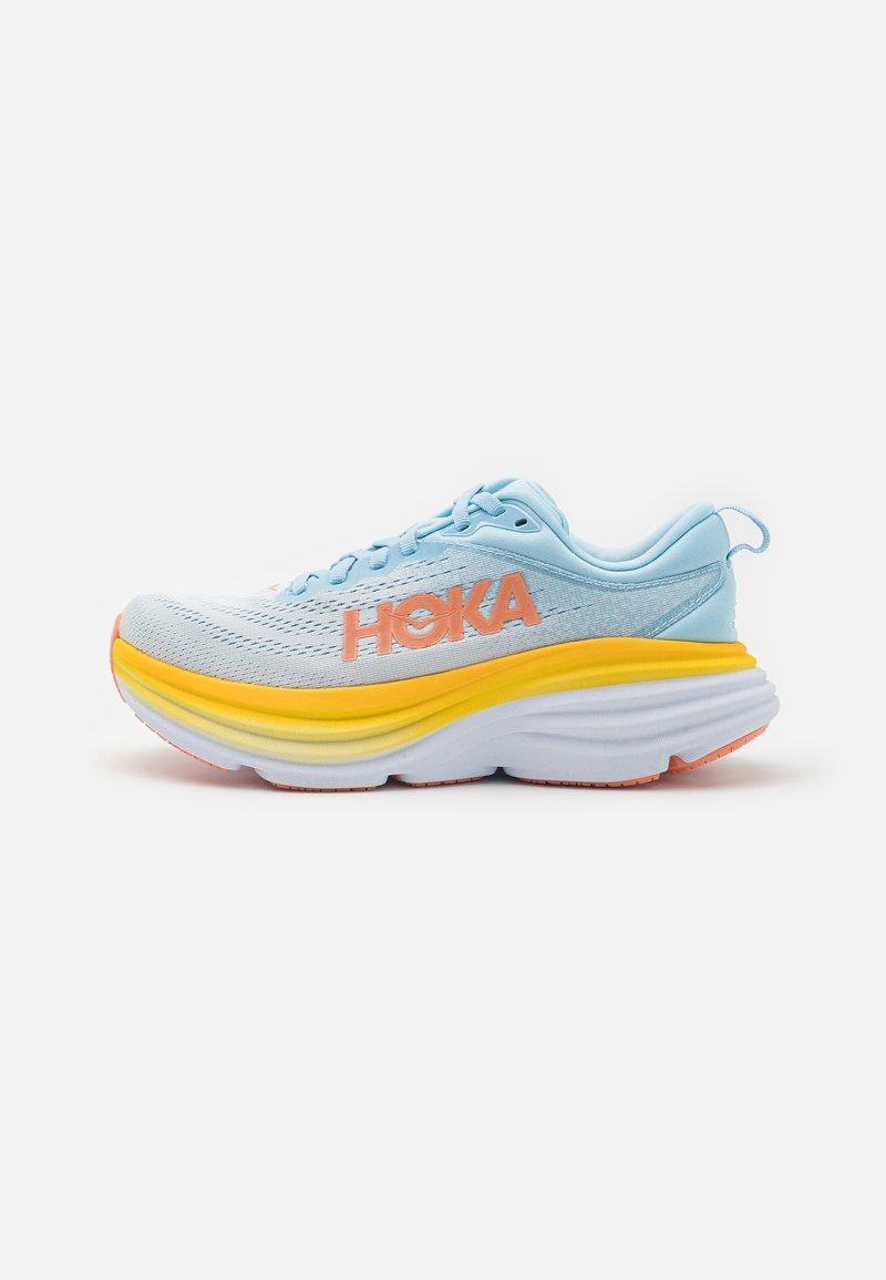 Helle blaue Laufschuhe mit einem atmungsaktiven Mesh-Obermaterial, orangefarbenem Logo, dicker gelber und weißer Sohle sowie strukturierten Mustern.