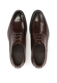 Scarpe eleganti in pelle marrone con una finitura liscia, allacciatura chiusa e sottili dettagli di cucitura. Design con punta rotonda e tacco basso.