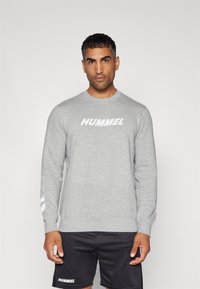 Grijze sweatshirt met lange mouwen van katoenmix, met een groot wit "HUMMEL" logo op de borst en strepen op de mouwen.
