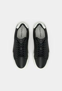 Μαύρα δερμάτινα αθλητικά παπούτσια με λεία υφή, με στρογγυλεμένο δάκτυλο, μαύρα κορδόνια και ασημένια λεπτομέρεια στη φτέρνα και στη μύτη.