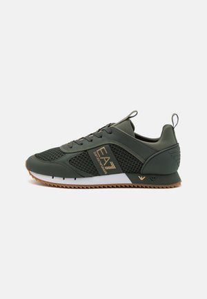 Zapatilla deportiva verde oscuro con paneles de malla, logo dorado EA7 Emporio Armani, suela marrón dentada, cordones negros y tiradores en el talón y la lengüeta.