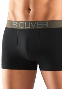 Crne bokserice s ravnim pojasom na kojem se u srebrnom slovima nalazi naziv "S.OLIVER". Glatki, uski dizajn s mekanom teksturom.