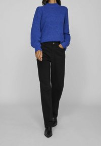 Blauwe gebreide trui met een hoge hals, gecombineerd met zwarte rechte broek en enkellaarsjes. Eenvoudig, textuurontwerp.