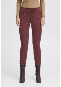 Burgundyröda sweatpants med dragsko i midjan, sidofickor och avsmalnande ben, tillverkade av mjukt bomullsmaterial.