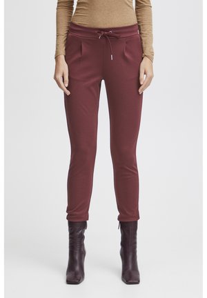Burgundy sweatpants with a drawstring waist, side pockets, and tapered legs, made from soft cotton material.