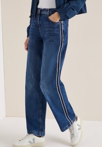 Donkerblauwe denim jeans met een rechte snit en witte zijkanten, met een klassieke vijf-pocket ontwerp en zichtbare stiksels.