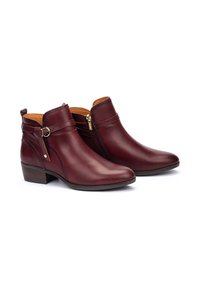 Botines de cuero burdeos con cremallera lateral, detalles de hebilla y un bajo tacón apilado. Textura suave con un diseño de puntera redondeada.