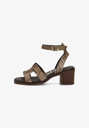 Sandalia marrón con estampado de piel de serpiente, punta abierta, correa en el tobillo, cierre de hebilla y tacón de bloque sobre fondo blanco.