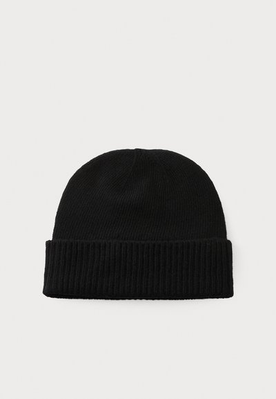 Gorro de malha preto com uma textura canelada e uma dobra na parte inferior, apresentando uma forma arredondada no topo.