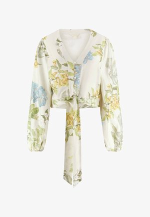 Blouse longue à manches longues couleur crème, col en V, boutonnée sur le devant, imprimé floral en bleu, jaune et vert, avec un nœud sur le devant à la taille.