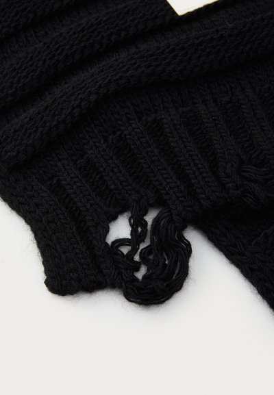 Mustvalt kootud riie, millel on soonik texture, koos rebenemisega, mis paljastab lõtvade niitide. Sisaldab horisontaalset disainielementi.