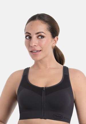 Schwarzer Sport-BH mit Frontreißverschluss, nahtlosem Design und Mesh-Einsätzen. Verfügt über breite Träger und ein Logo am unteren Rand zur Markenkennzeichnung.