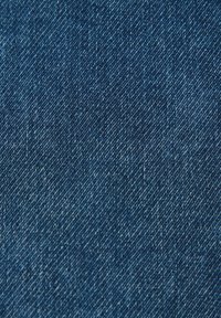 Ciemnoniebieska tkanina dżinsowa z subtelną teksturą i przekątnym splotem, charakteryzująca się gładką powierzchnią i starannym przeszyciem.