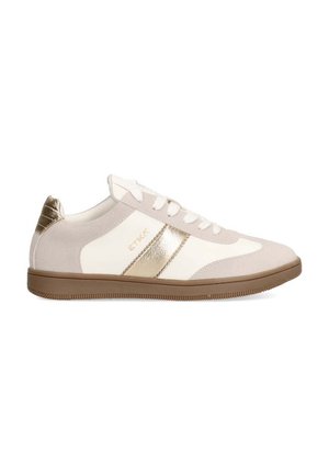 Zapatilla beige y blanca con acentos dorados, materiales de ante y cuero, punta redondeada y suela de goma con un patrón texturizado.