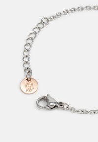 Sølv lenkearmbånd med en rose gold charm med inngravert logo, ferdig med en krabbe-lås for sikker lukking.