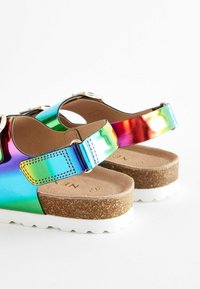Färgglada sandaler med metallisk finish, utrustade med en korksula, vit plattform och justerbara remmar med spännen.
