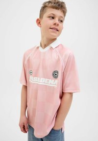 Camiseta de fútbol a cuadros rosa con cuello blanco y marca. Mangas cortas y corte relajado, hecha de material sintético ligero.
