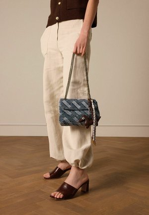 Woven blue and gray handbag with a chain strap, featuring a brown horse accent and tassels. Displays a rectangular shape and structured design.