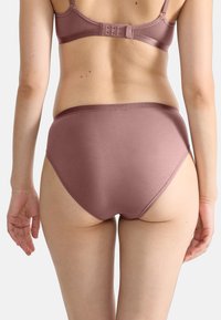 Brzuchy z wysokim stanem w kolorze mauve, wykonane z miękkiego, fakturowanego materiału. Posiadają gładką talię i dyskretne szwy dla komfortu.