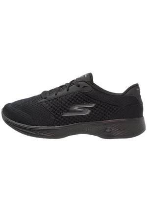Chaussure de sport noire avec une tige en mesh, des panneaux texturés et une semelle synthétique. Design à lacets avec un accent logo sur le côté.