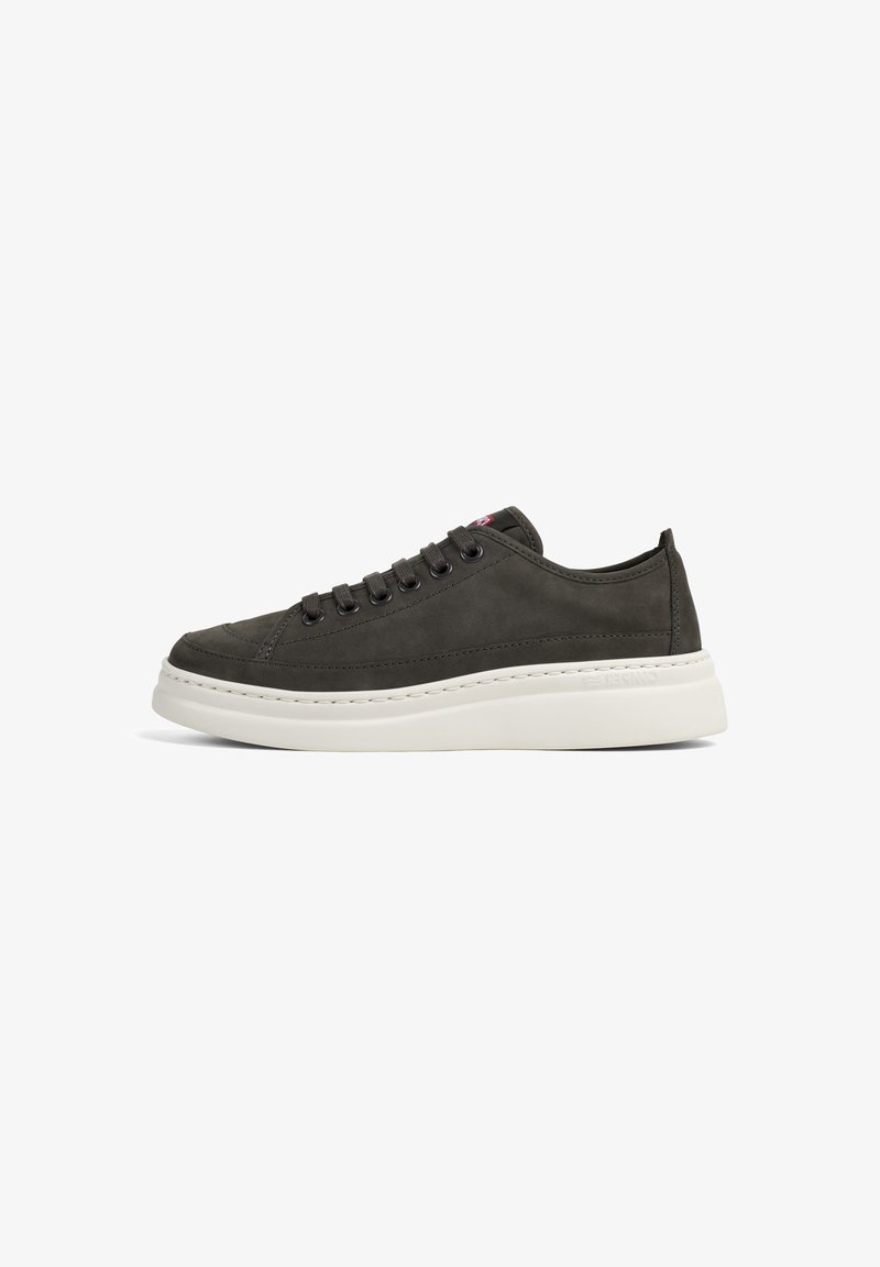 Sneaker en cuir gris foncé avec bout rond, système de laçage et semelle en caoutchouc blanc. Présente des coutures discrètes et un logo sur le talon.